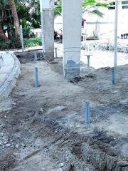 Helical piles are installed with new construction brackets positioned.