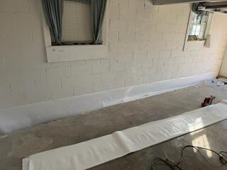 Step 2: We then covered the weeping holes with our Wall-E system, (not to be confused with the movie). This vapor barrier will make sure that the weeping holes drain right into the trench.