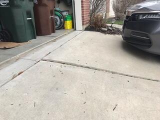 This photo was taken upon the initial inspection and shows the two settled slabs attached to the garage opening. These two sunken slabs could have caused someone to trip.