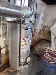 The basement before waterproofing, showing damp conditions, water staining, and moisture damage along the block walls.
