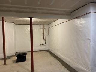 WaterGuard drainage system installed along the interior perimeter to capture water seeping through the walls and floor and direct it safely to the sump system.