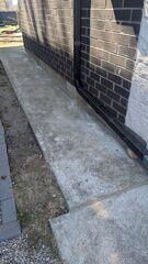 As the slabs sank, the downspout was left unsupported and pulled out of position. Our repair restored the height of the concrete to support the drainage system and keep it properly connected.