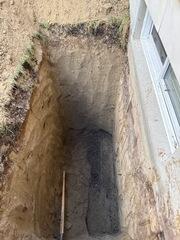 Pit dugged out to start waterproofing the exterior foundation wall.