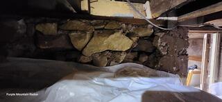 The original radon contractor faced stone walls and low clearance when installing the vapor barrier. The vapor barrier was unable to be sealed at the perimeter.
