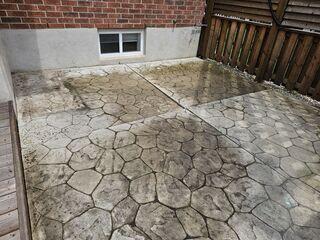 This patio was sinking at the relief cuts, creating deep "valleys" in the center of the stamped concrete. These uneven joints created major trip hazards and allowed water to pool against the home.