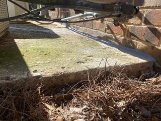 This photo shows the concrete slab supporting the home's HVAC system after it was lifted and stabilized using PolyLevel® concrete lifting. The slab had previously settled several inches, causing water to pool near the home's exterior wall. Raising the slab helped restore proper support for the HVAC system and improved drainage away from the foundation.