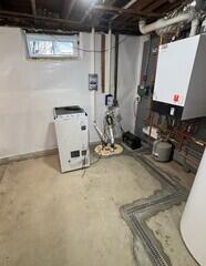 The SaniDry XP dehumidifier keeps humidity in the basement low and drains itself into the TripleSafe sump pump which sends all of the collected water out of the home through two discharge lines.