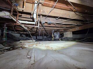 The state of the damp crawl space before the project.
