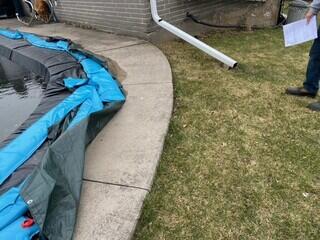 This shot shows our team evaluating the pool perimeter during the off-season. It clearly illustrates the uneven joints and the soil erosion occurring near the downspout, which contributed to the sinking of these massive concrete sections.