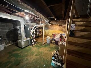 Before waterproofing, the unfinished basement showed severe wall staining and long-term water damage from groundwater intrusion.