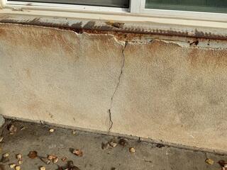 Vertical crack in exterior foundation wall of Clearfield, UT home indicating structural movement and settlement requiring foundation repair with push piers.