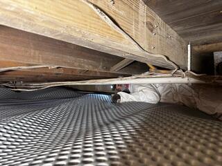 Our crew managed to squeeze into the crawl space to install the drainage matting and encapsulation liner.