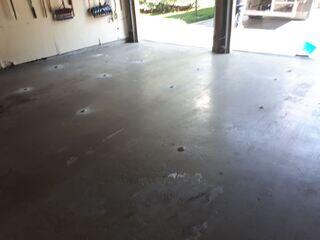 Final result of garage floor repair in Pickering: sunken concrete slabs have been lifted and stabilized using polyurethane concrete leveling. Tripping hazards and gaps are eliminated, and the floor is now solid and ready for vehicle use, with only small filled injection points visible.