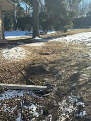 Mid-Install: Holes are dug beyond the foundation wall for anchor placement.