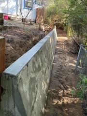 The finished product! A strong and sturdy Retaining Wall to hold the hillside and place, and prevent any further ground shifting around the foundation of the nearby home.