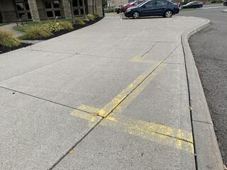 A closer view shows the shifted slabs and vertical gaps, making the walkway unsafe and non-compliant for anyone using a wheelchair or walker.