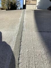 A close-up of the seam between the driveway and garage floor after our poly-injection process. We lifted the sunken slab with high-density polymer and sealed all cracks with premium joint sealant to prevent future water intrusion and stabilize the surface.