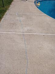 Even our rubber duck friend could see the trouble! This view highlights the long, jagged crack caused by shifting soil, creating a significant poolside trip hazard.