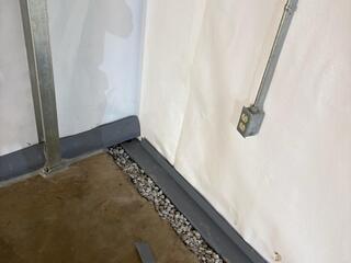 This photo shows where the DryTrak baseboard drain (to the left) meets the WaterGuard subfloor drain (to the right). We all know the saying, "Water flows downhill." The baseboard drains sits higher than the WaterGuard, so water will channel down to the right of this photo.