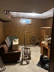 Another paneled room with furniture and belongings.