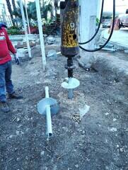 Installing helical pile 10"-12"-14" lead section with 14" extension in foreground