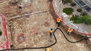 Aerial view of excavated area with utilities marked and partially exposed.