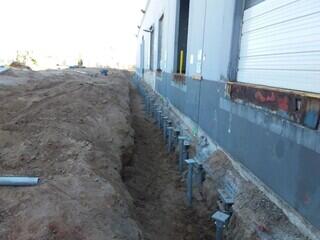Retrofit helical piles and new construction helical piles at north wall