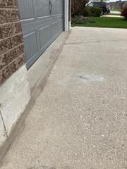 At the most high-traffic point of the property, the driveway had pulled away from the garage floor. This created a deep, debris-filled gap and a significant "lip" that made for a bumpy entrance every time a car pulled in. It also left the garage foundation vulnerable to water pooling right at the seal.