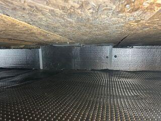Installation de la membrane pare-vapeur CleanSpace afin de sceller et protéger le vide sanitaire. Panneaux isolants SilverGlo™ installés le long des murs pour améliorer l'efficacité énergétique.