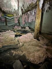 Nasty crawl space with hanging insulation and large amounts of water damage.