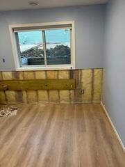Our crew drilled the steel pole through the wall, which would connect both the interior and earth anchors.