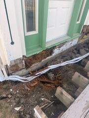 Extensive wood deterioration along the lower exterior wall behind the porch in Roxbury, Vermont. We cut back a section of the porch to access the area of concern.