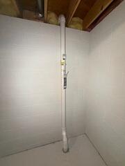 The piping installed through the concrete floor in the basement