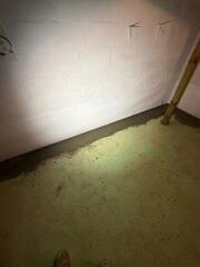 The crew re-concretes the floor once the system is installed. There is a small gap between the wall and the trench that allows water seepage from the walls to drain through.