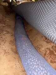 A Section of our EzFlow Crawl Space Drainage System being installed in this crawl space.