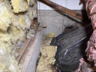 Fallen fiberglass insulation due to moisture build up from water intrusion.