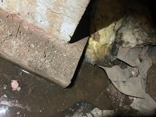 Water pooling at the corners of the foundation with no proper drainage.
