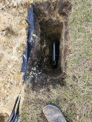 The earth anchor placed in the hole and connected to the interior wall plate