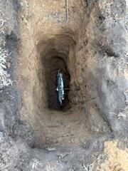The earth anchor is placed inside of the hole and connected to the interior wall plate using a small steel pole
