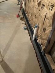 Our crew in the process of installing WaterGuard along the perimeter of the basement