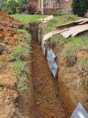 Excavation around the home allowed our team to install the exterior earth anchors that are connected to the interior Wall Anchor System. Together, these components permanently stabilize bowing foundation walls by resisting the lateral pressure created by the surrounding soil.