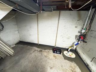To finish, the crew installs the new TripleSafe sump pump and re-concretes the floors.
