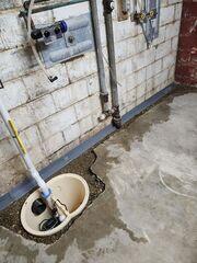 Our crew drilled a sump pit and the edges of the floor. Then, WaterGuard and components of the sump pump were placed, and the areas were backfilled.
