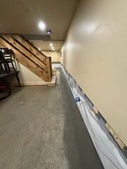 A below-floor interior drainage system is installed around the basement perimeter to capture water and direct it toward the sump pump system. Installed along the foundation walls to intercept wall water and direct it downward into WaterGuard while providing a clean, bright wall surface behind the finished walls.