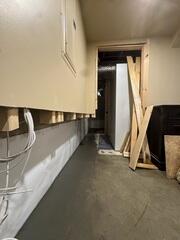 A below-floor interior drainage system is installed around the basement perimeter to capture water and direct it toward the sump pump system. Installed along the foundation walls to intercept wall water and direct it downward into WaterGuard while providing a clean, bright wall surface behind the finished walls.
