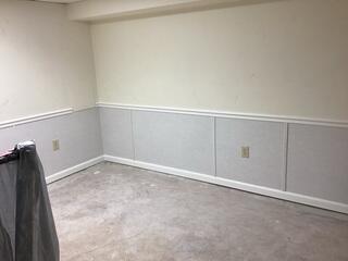 The crew re-finishes the basement walls with our Total Basement Finishing wall panels.