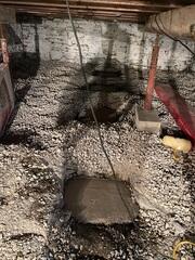 The crew excavated a portion of the ground in the crawl space to pour concrete footings for the Jacks.