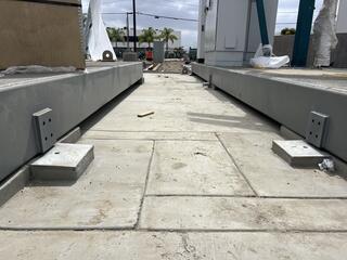 Skid beams resting on helical pile caps awaiting final attachment with steel angle