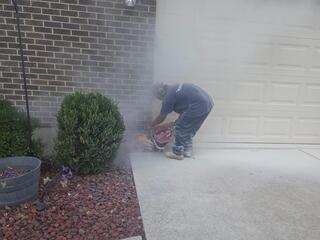 This photo was taken on the day of installation. Here we are relieving the garage slab of lateral pressure by cutting out a strip of concrete in the driveway across the garage door opening.