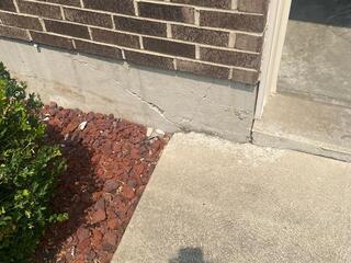 This photo, taken by Steve on the initial inspection, shows the exterior cracking the homeowner wasn't made aware of by the other contractors. This type of cracking is almost an indefinite sign of street creep occuring. See how the driveway slab is crumbling where it meets the garage foundation?